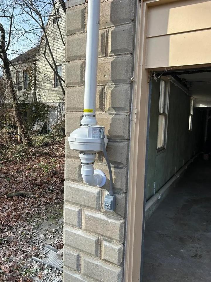 Discreet exterior radon vent pipe on a brick St. Louis home, preserving the home's appearance