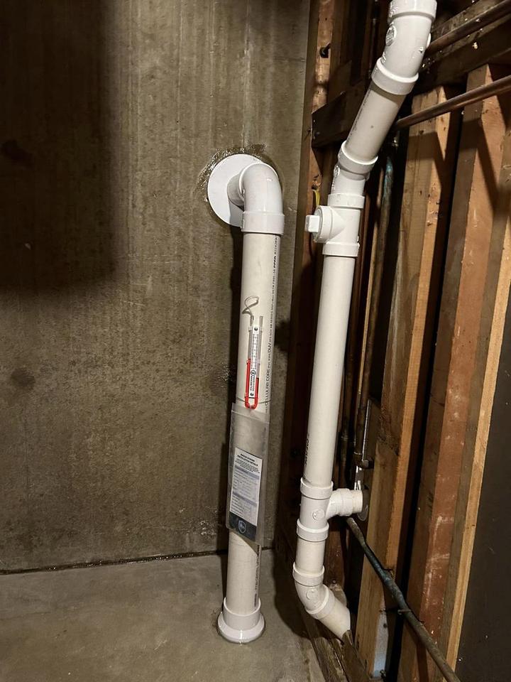 Multi-point basement radon mitigation piping with a pressure manometer installed by Air Sense Environmental