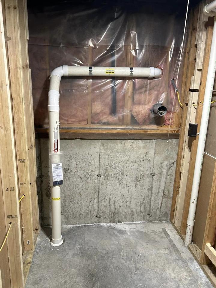 Air Sense Environmental sub-slab radon mitigation system with a U-tube manometer in a St. Louis area basement