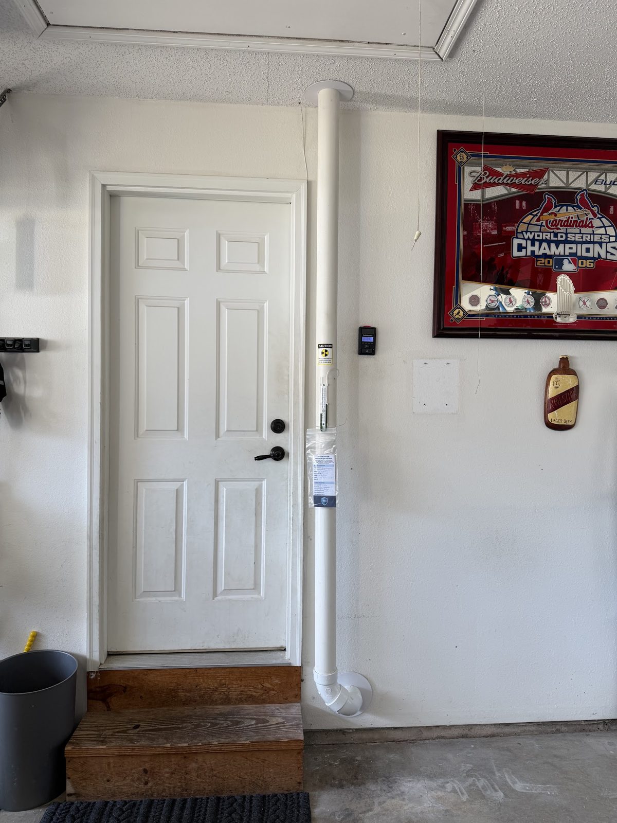 Radon vent pipe with manometer on a garage wall in Chesterfield, Missouri